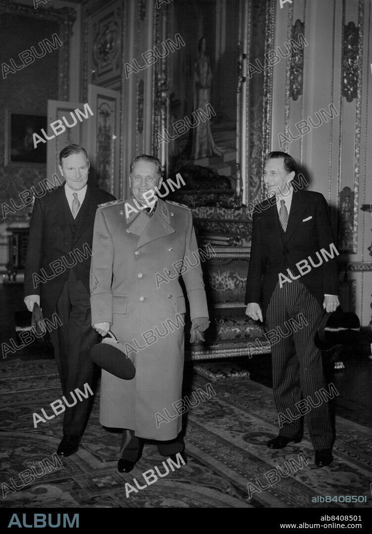 Tito Visits Windsor Castle -- Yugoslav President Marshal Josip Broz Tito, military cap in hand, smiles as he walks through the Crimson Darwing-room during his visit to Windsor Castle today (Friday).Accompanying the President are Lieutenant-Governor of the Castle (left) and Sir James Mann Surveyor of the Queen's Art.Marshal Tito also visited Hampton Court Palace today. March 20, 1953. (Photo by Reuterphoto).