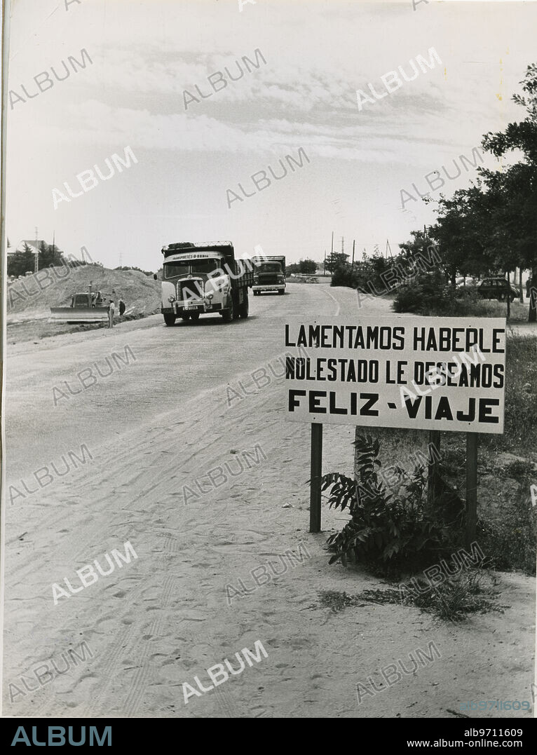 Madrid, 1964.- Un cartel de disculpa por las molestias causadas por las obras en la autovía de La Coruña.