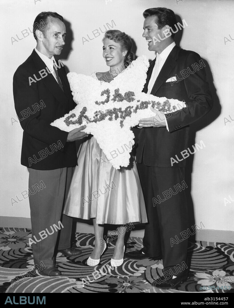 Los Angeles, California:  1952 Noted dance instructer Ernest Belcher presents his daughter, Marge, and son-in-law Gower Champion, with a floral wreath for their performance in the MGM film musical 'Everything I Have Is Yours'.
