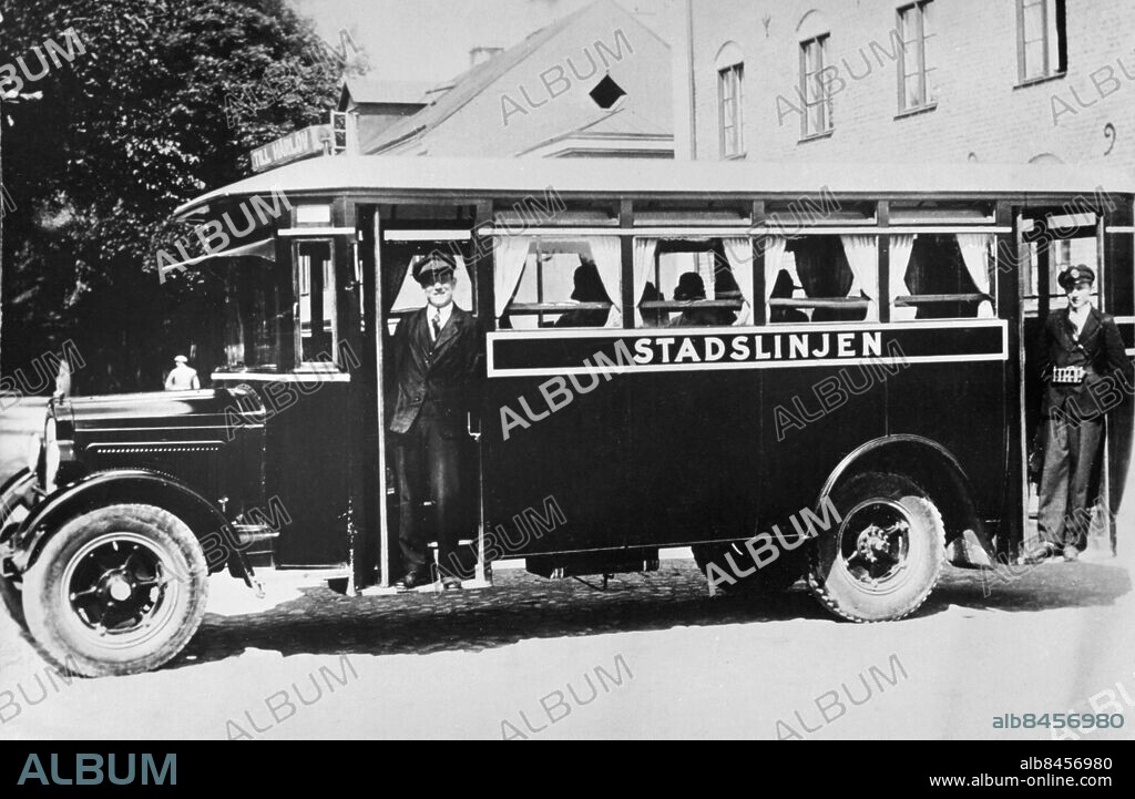 KRISTIANSTAD 1920-tal.. Orig. bildtext... Den första bussen på stadslinjen i Kristianstad med plats för 22 passagerare. Busschaufför var Evert Bladh som arbetade från starten 1928 fram till 1971. Hans kollega, Seved Åkesson, var konduktör på den första bussen i Kristianstad. Anm. Text Mössor Gardiner CD507 persons: SEVED ÅKESSON;EVERT BLADH sites: KRISTIANSTAD;SVERIGE.