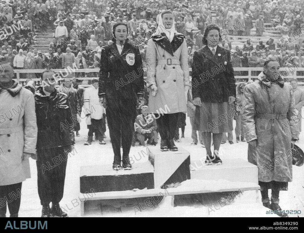 Women Receive Medals After Olympics -- Barbara Ann Scott (centre) the Canadian girl champion, who is also the world's and European skating champion, standing on the Olympic pedestal to receive the Olympic gold medal for winning the Womens' Figure Skating event. At right is Jeannette Altwegg (Great Britain) who was second, and on left is Eva Palik (Austria) who was placed third. The presentation ceremony took place in a snowstorm. February 08, 1948.