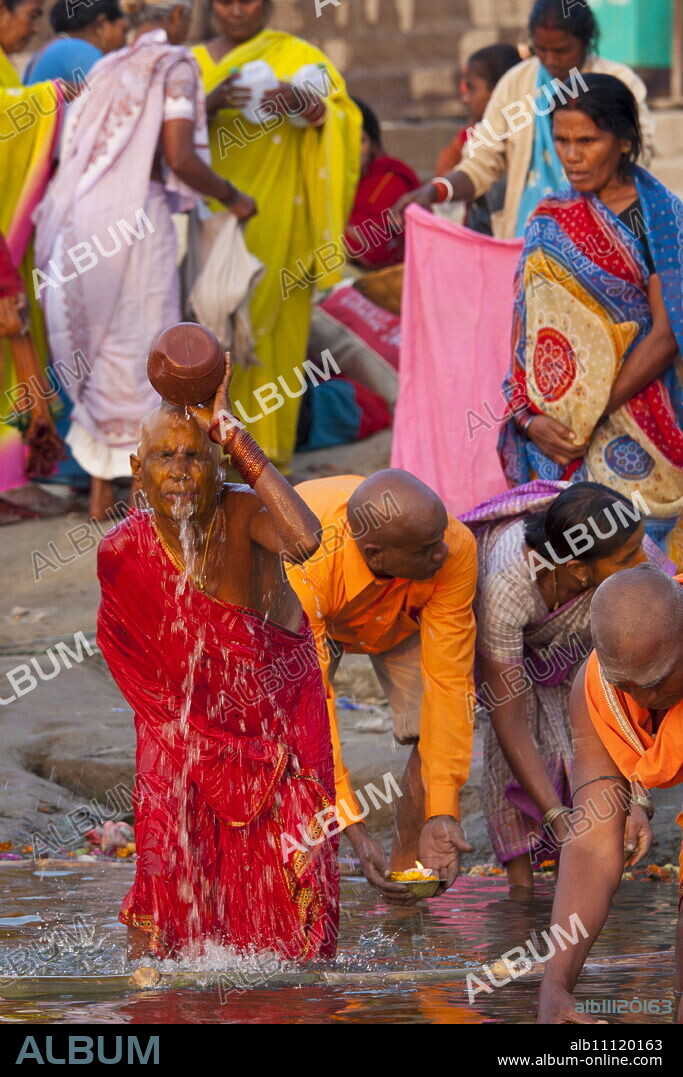 Indian Hindu pilgrims bathing in The Ganges River at Dashashwamedh Ghat in Holy City of Varanasi, Benares, India.
