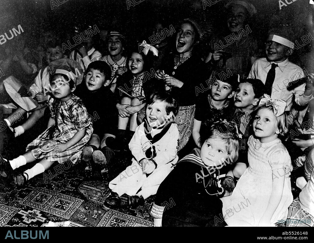 Mrs. A.V. Alexander Entertains United Nations Children: Happy Like his grandfather in the centre front is Master Winston Churchill, son of the Premier, Laughing at the Punch and Judy show with other Allied Children.Mrs. A.V. Alexander, Wife of the First Sea Lord of the Admiralty recently entertained children of Sixteen Allied Nations to a tea party at Admiralty House. The rooms were gay with decorations made of ear salvage. Comjuring tricks and the Punch and Judy were the most popular  events with the children. Nearly 150 children of 16 Allied nations were present.  December 01, 1943. (Photo by British Official Photograph).