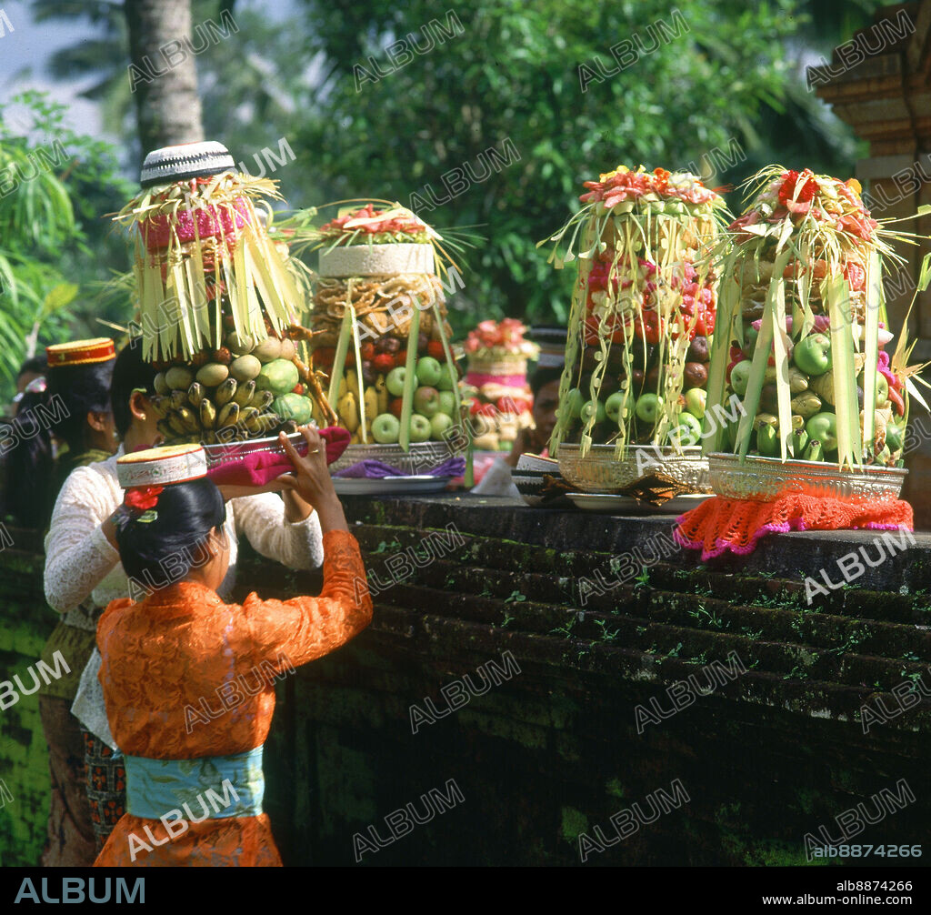 CEREMONIA HINDUISTA-MUJERES DEPOSITAN CESTAS DE FRUTAS COMO OFRENDA.