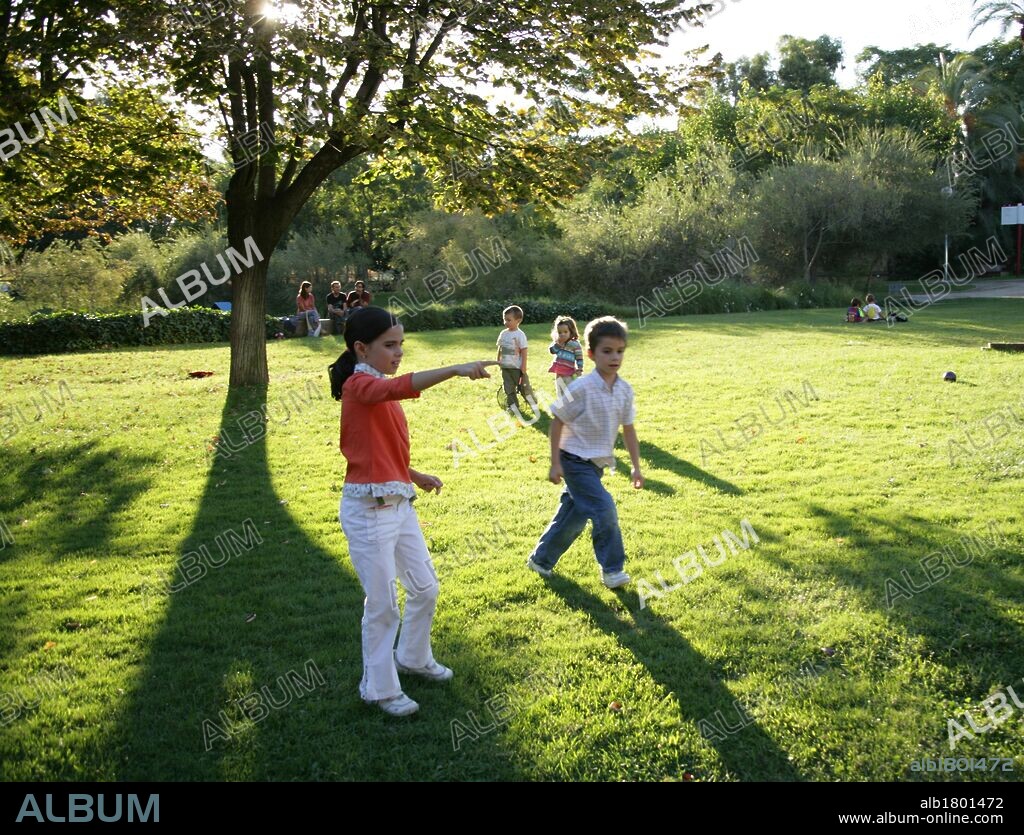 Niña de siete años y niño de seis años jugando en un parque.
