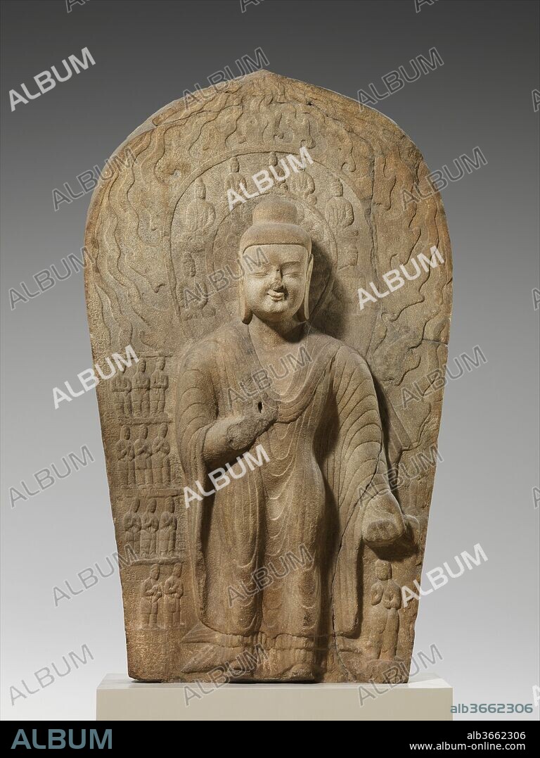 Buddha Dipankara (Diguang). Culture: China. Dimensions: H. 127 in. (322.6 cm); W. 75 in. (190.5 cm); D. 28 in. (71.1 cm); H. with base: 137 in. (348 cm). Date: dated 489-95.
The inscription on the back of this stele identifies the Buddha depicted on the front as Dipankara, who was thought to have lived before the historical Buddha Shakyamuni. He is shown here attended by a group of small figures wearing the clothing of the Xianbei, the non-Han Chinese peoples who ruled the Northern Wei dynasty. The smaller standing figure to the Buddha's right may represent a youth named Sumedha, who was destined to become the historical Buddha in another lifetime. The imagery of this large sculpture is therefore intended to illustrate the promise or possibility of enlightenment in a future life. In Buddhism, the achievement of this advanced spiritual state is the goal of all practitioners. 
The bodhisattva with crossed ankles on the back of the stele recalls similar figures in the collection from the Yungang cave temple complex.