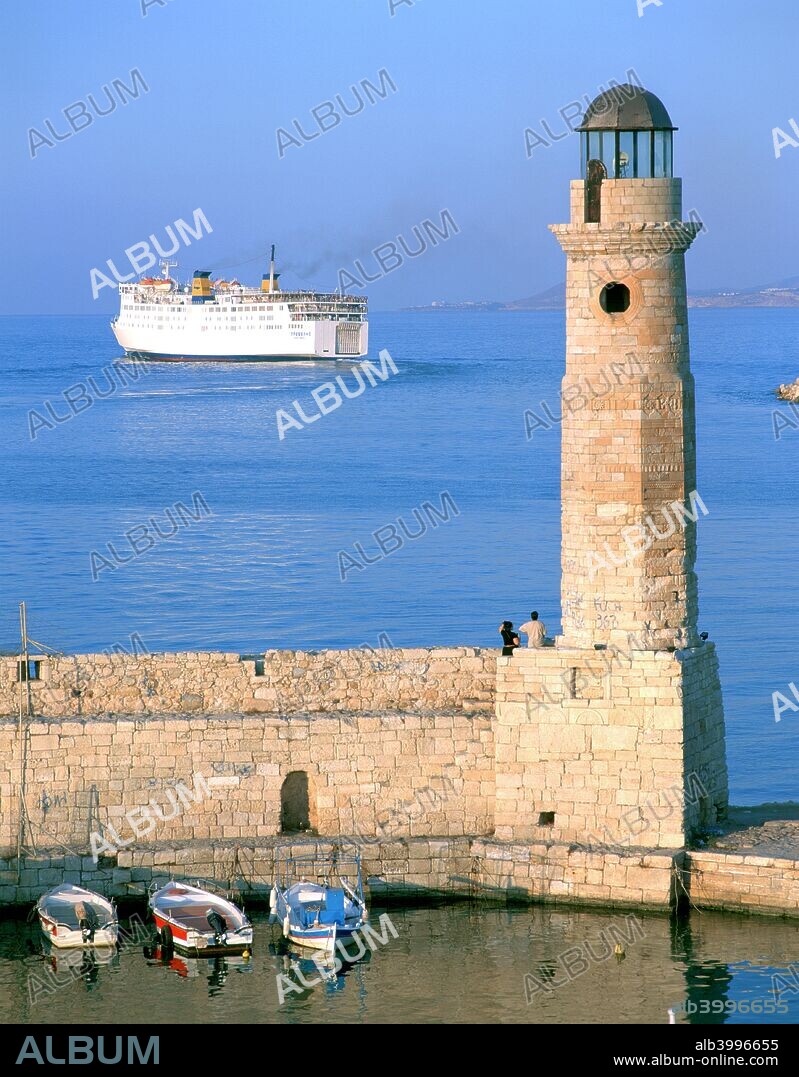 Venetian lighthouse and the ferry to Piraeus, Rethymnon, Crete, Greece. Much of the town of Rethymnon was built by the Venetians, who ruled Crete from 1204 until the mid 17th century.