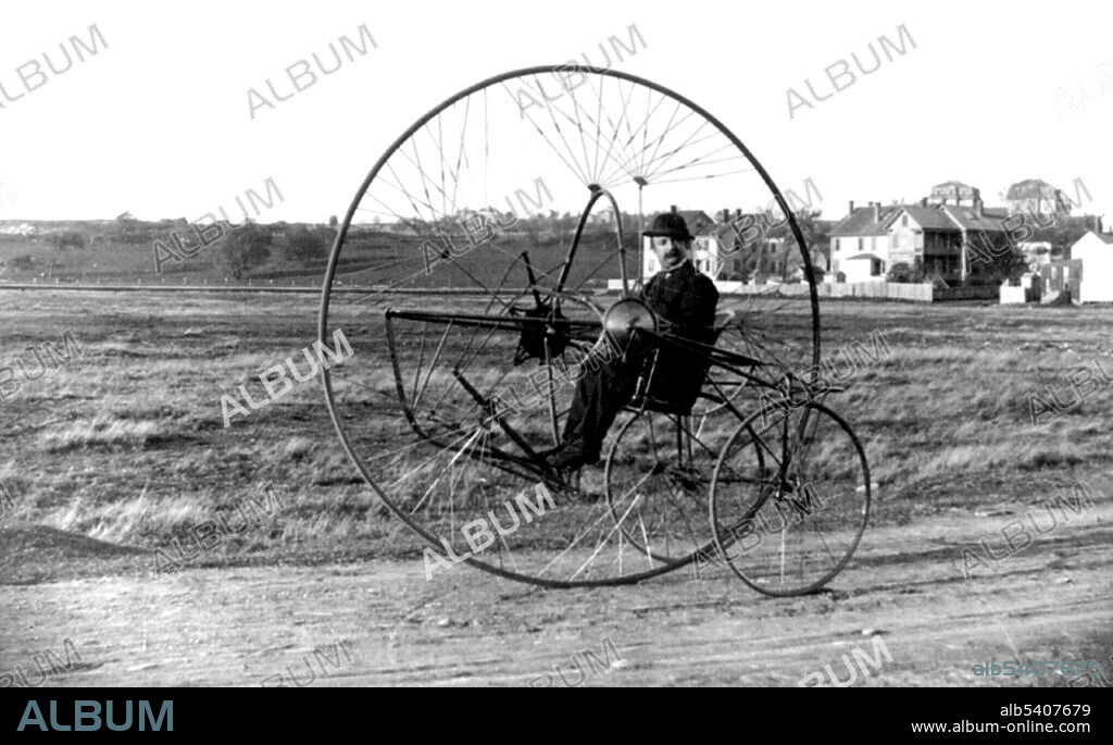 View of Charles Oldreive's new tricycle, or the New Iron Horse, with a gentleman inside. In 1876, James Starley developed the Coventry Lever Tricycle, which used two small wheels on the right side and a large drive wheel on the left side; power was supplied by hand levers. In 1877, Starley developed a new vehicle he called the Coventry Rotary, which was one of the first rotary chain drive tricycles. By 1884, there were over 120 different models produced by 20 manufacturers. Tricycles were used by riders who did not feel comfortable on the high wheelers, such as women who wore long, flowing dresses.  Photographed by Charles Wood Oldreive, 1882.