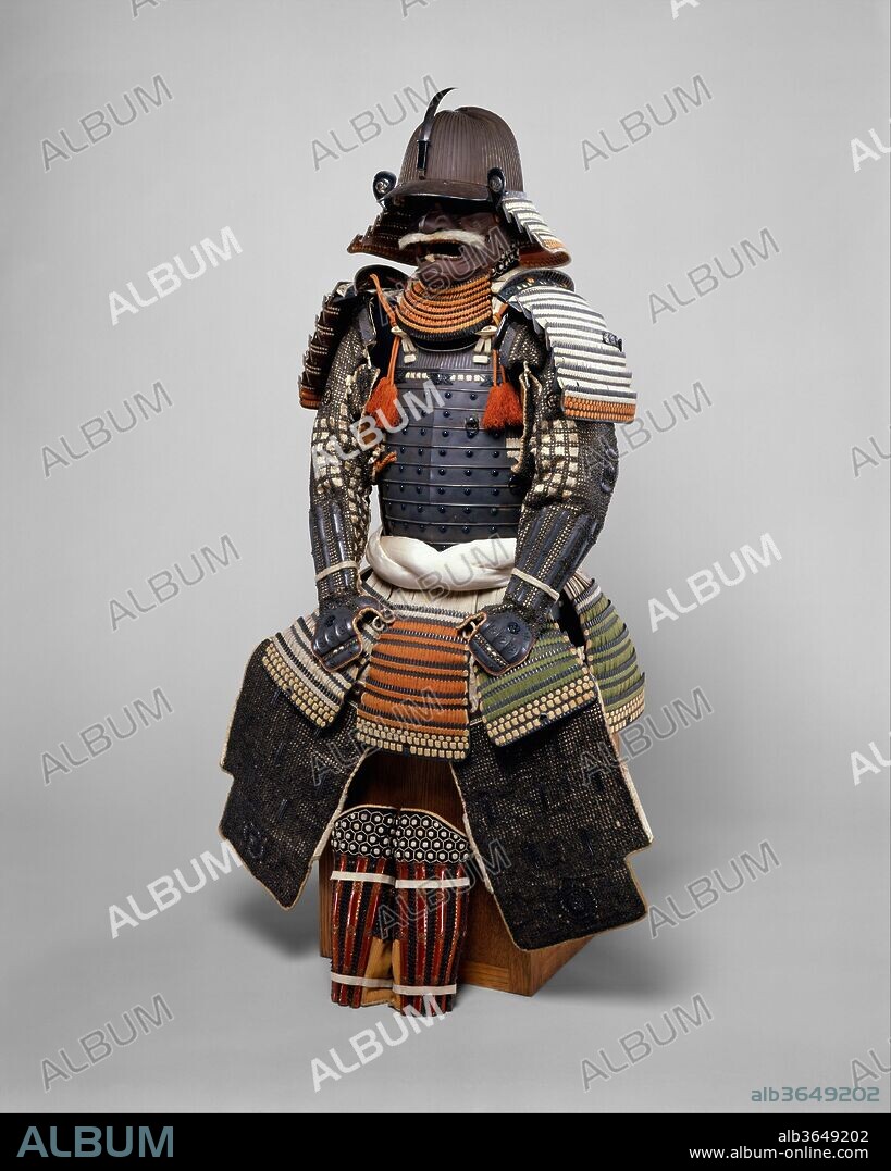 Armor (Gusoku). Armorer: Helmet signed by Bamen Tomotsugu (Japanese, Eichizan province, Toyohara, active 18th century). Culture: Japanese, Toyohara, Eichizan province. Dimensions: as mounted, H. 58 5/8 in. (148.8 cm); W. 18 3/4 in. (47.6 cm). Date: 18th century.
The workmanship of this armor and its materials are of the highest quality. It features a <i>kusazuri</i> (skirt) with an extremely rare color scheme of silk lacings in red, yellowish-green, black, and white. The <i>mon</i> (heraldic badge), in the form of three whirling commas (<i>mitsudomoe mon</i>), is that of the Okabe family, feudal lords of Kishiwada (present day Kishiwada City in Osaka Prefecture). The armor is signed on the inside of the helmet: <i>Eichizan no Kuni Toyohara ju Bamen Tomotsugu Saku</i> (Bamen Tomotsugu living in Eichizan province, Toyohara village). Bamen Tomotsugu was the leading armorer of the Bamen school in the eighteenth century. Complete armors signed by him are extremely rare.