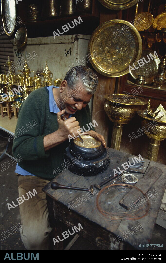 Portrait of a craftsman at work in a copper souk, Khan el Khalili Bazaar, Cairo, Egypt, North Africa, Africa.