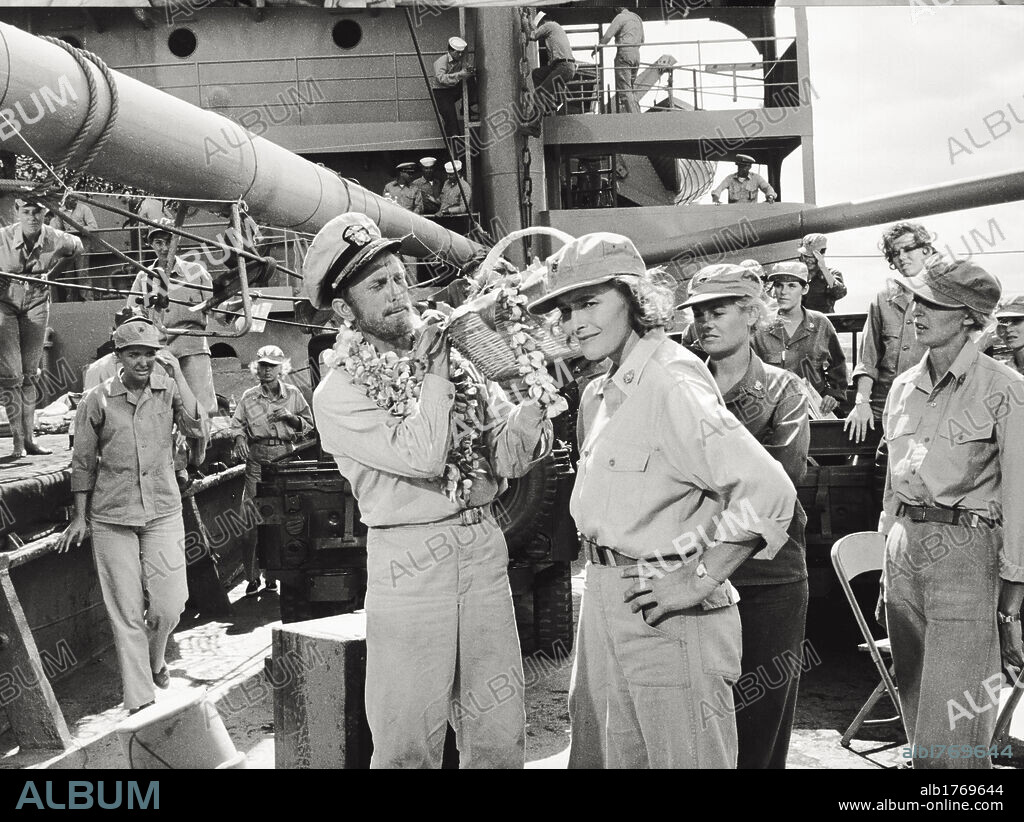 Kirk Douglas and Patricia Neal in the film 'In Harm's Way'. The US actor Kirk Douglas, on the bridge of a military ship, carries a basket of bananas and garlands to the actress Patricia Neal, in a scene of 'In Harm's Way'. Hawaii (United States), 1965.