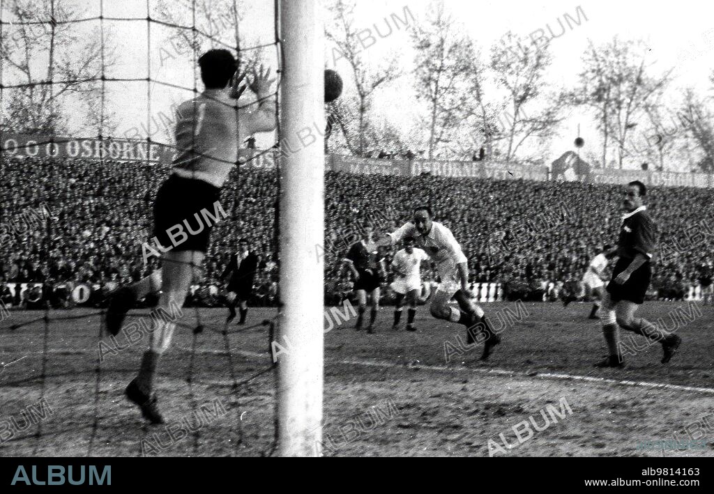 Un remate del delantero centro del Sevilla F. C., Araujo, con parada del portero del independiente de Avellaneda, Abraham, en un partido amistoso Disputado el día 17 de diciembre de 1953 en el campo de Nervión. El partido Finalizó con empate A uno con goles de Loren, para el Sevilla, y Juárez, para el Independiente, tras lanzar un Penalti. El equipo argentino se Hallaba de gira por Europa y el de Nervión Fue el único partido que no Ganó. El independiente de Avellaneda Fue Fundado en el año 1905, igual que el Sevilla. (foto Serrano).