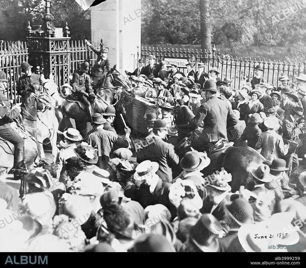 Riot at the Constitution Hill gate of Buckingham Palace, 21st May 1914. Two women on the right pull at the reins of a police horse. A woman behind the horse  climbs onto the railings. The suffragettes had wanted to seek an audience with  King George V. He declined to receive them and the riot ensued. There were many reports of police brutality.