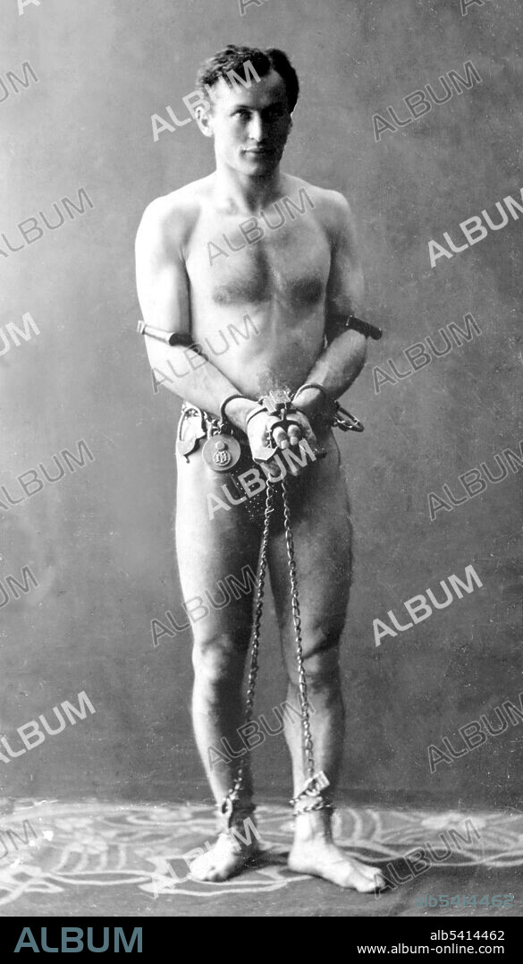 Houdini in chains. Harry Houdini (1874 - 1926) was a Hungarian-American illusionist and stunt performer, noted for his sensational escape acts. His repertoire included chains, ropes slung from skyscrapers, straitjackets under water, holding his breath inside a sealed milk can, and being buried alive. McManus-Young Collection, 1900 (cropped and cleaned).