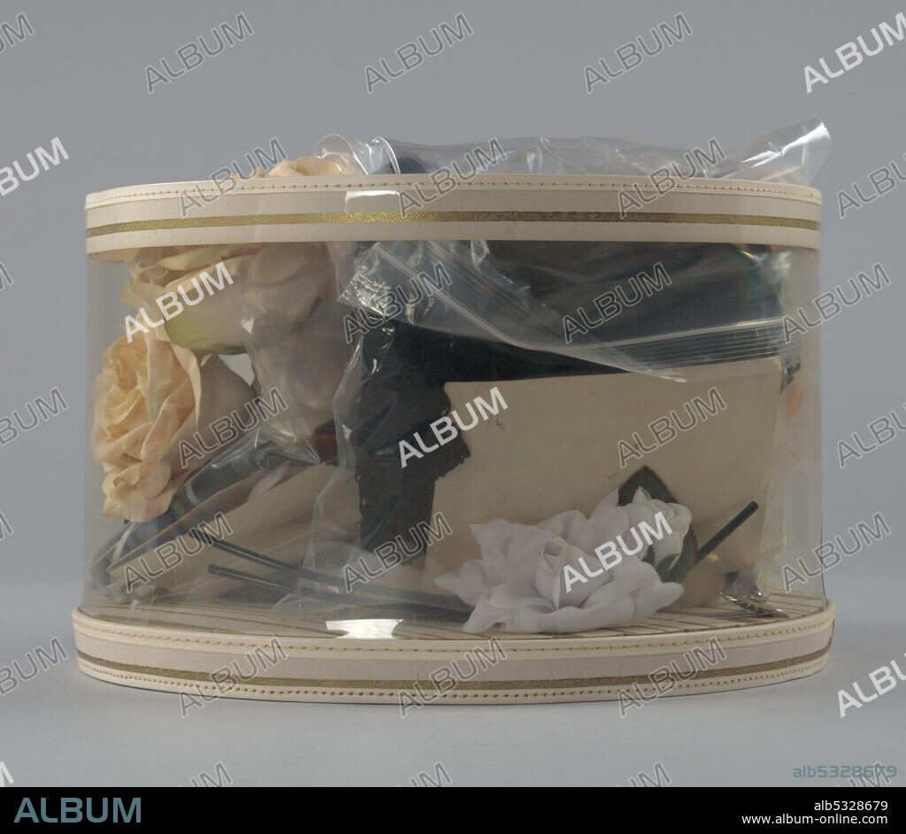 Hat box without lid made from a pasteboard bottom printed in cream and gold stripes, and clear plastic sides. Mae Reeves (1912-2016) was a pioneering African-American milliner who was famous for her custom-made hats. Her business, Mae's Millinery Shop in downtown Philadelphia, was one of the first shops in the city to be owned by a woman of African American heritage.