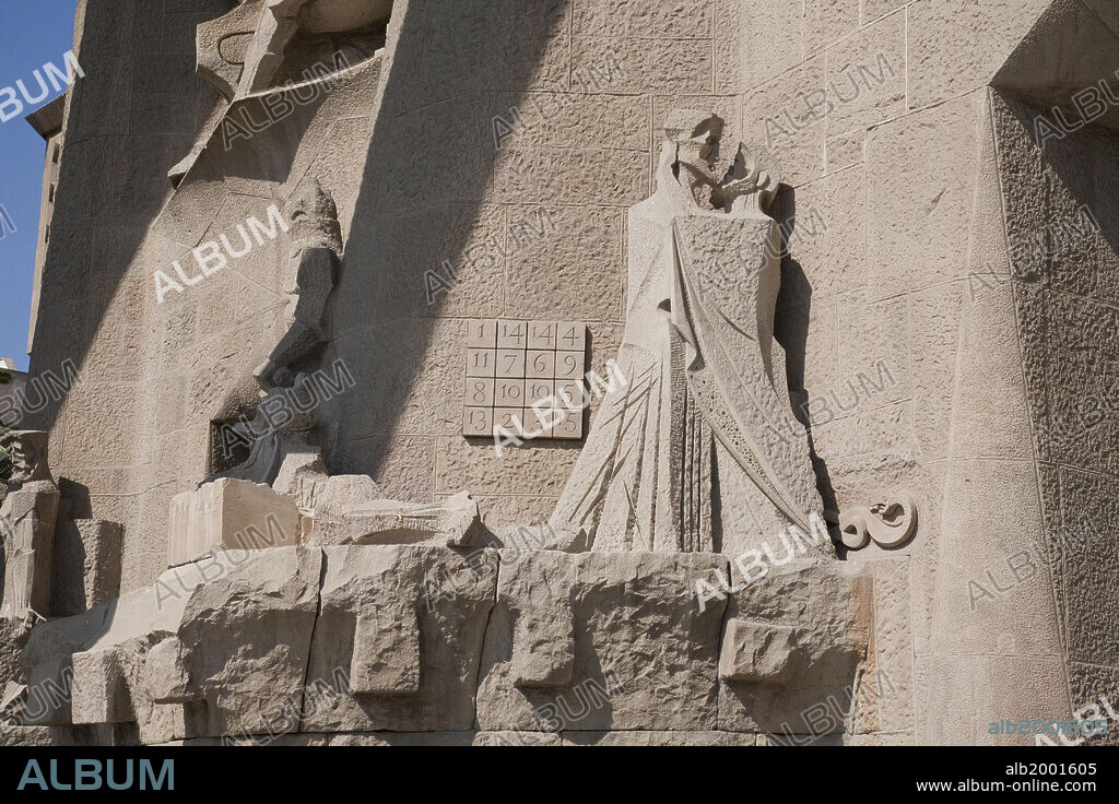 The construction of this unique Temple began in 1882, and one year later Antoni Gaudi was appointed Project Director. He worked on the project over 40 years until his death in 1926. The temple has three facades (named: 'Nativity', 'Passion' and 'Glory'), each bearing four souring towers. Eight of the twelve bell towers of the facades, dedicated to the Apostles and having a height exceeding 100 meters, are already built. The four belfries awaiting construction are those of the Facade of Glory, the 170-meter central dome in honor of Jesus Christ, the Tower of the Virgin Mary (125m) and the Tower of the 4 Evangelists. Seen here are statues by the sculptor Josep Maria Subirachs on the Passion Facade (southwestern lateral facade). Subirachs began his work in 1987 following the ideas of Gaudi, but not his style. In this scene: The kiss of betrayal of Judas. A snake on the wall next to Judas' feet represents the devil who tempted him to betray Jesus. On the wall behind is a numerical magic square (cryptogram), that contains 16 numbers offering a total of 310 combinations all adding up to 33, the age of Christ at his death.