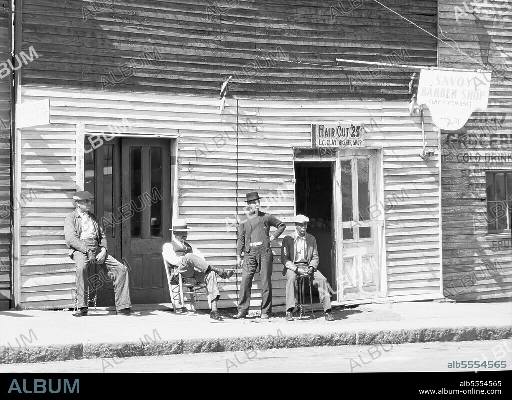 WALKER EVANS. Vicksburg Negroes and shop front. Mississippi. ['Hair Cut 25 cents - E.C. Clay Barber Shop; Savoy Barber Shop'].