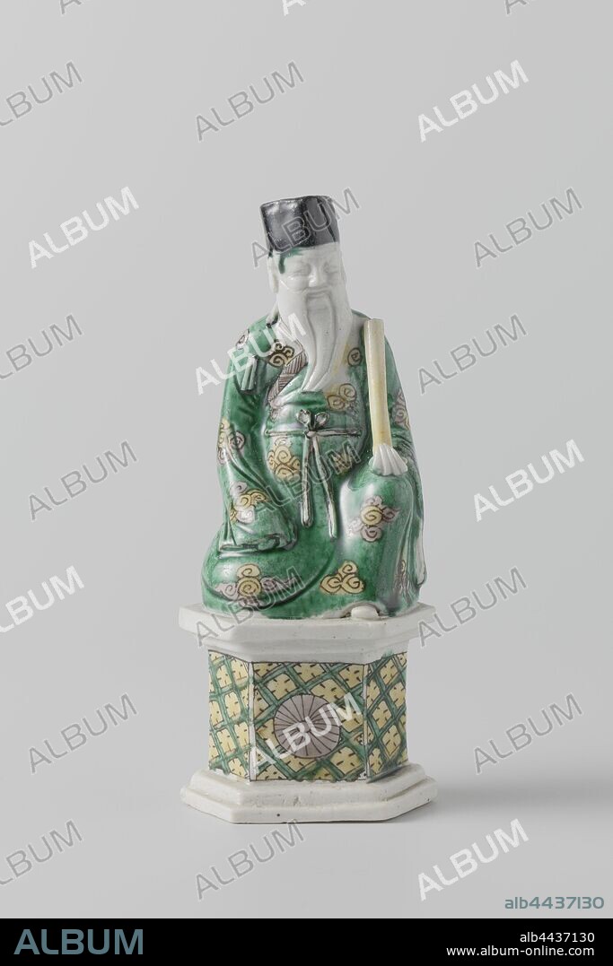 Seated figure of Zhang GuoLao, one of the Eight Immortals, Porcelain image on hexagonal base, painted on biscuits in green, yellow, eggplant and black. It depicts the sitting Zhang GuoLao, in a robe of clouds. His attribute, a bamboo percussion instrument, rests on his left knee. The hexagonal pedestal is adorned with napkin work on the front with a stylized chrysanthemum in it, two separate flowers and a diamond on the back. The sticks of the percussion instrument are broken off. Email sur biscuit with famille verte colors., anonymous, China, c. 1700 - c. 1724, Qing-dynasty (1644-1912) / Kangxi-period (1662-1722) / Yongzheng-period (1723-1735), porcelain (material), glaze, vitrification, h 15 cm l 6.3 cm × w 4.1 cm.