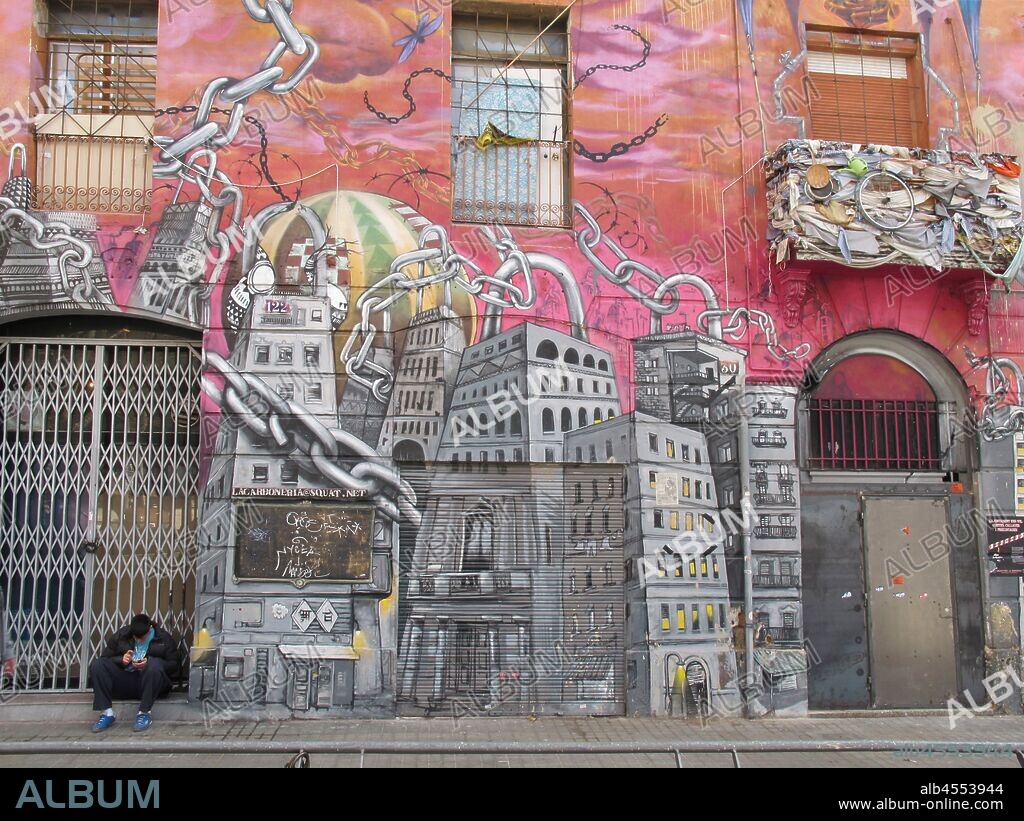 Pintura de ciudad con cadenas en la pared de un edificio que tiene las ventanas tapiadas, graffiti mural, calle Conde de Urguell; distrito Ensanche, Barcelona en 2014.