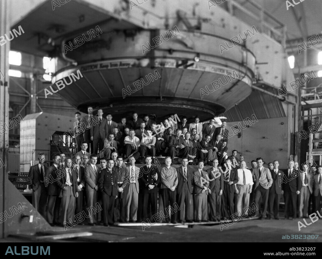 In 1945-46, the 184 inch was converted from a calutron to a synchrocyclotron; Lawrence and staff posed with the magnet. Ernest Orlando Lawrence (August 8, 1901 - August 27, 1958) was an American physicist and Nobel Laureate, known for his invention, utilization, and improvement of the cyclotron atom-smasher beginning in 1929, based on his studies of the works of Rolf Wideroe, and his later work in uranium-isotope separation for the Manhattan Project. Lawrence had a long career at the University of California, Berkeley, where he became a Professor of Physics. In 1939, Lawrence was awarded the Nobel Prize in Physics for his work in inventing the cyclotron and developing its applications. After the war, Lawrence campaigned extensively for government sponsorship of large scientific programs. Lawrence was a forceful advocate of "Big Science" with its requirements for big machines and big money. He'd died in 1958 at the age of 57. After his death, the Regents of the University of California voted to rename two of the university's nuclear research sites after Lawrence: the Lawrence Livermore and Lawrence Berkeley Laboratories. Chemical element number 103, discovered at LBNL in 1961, is named "lawrencium" in his honor.
