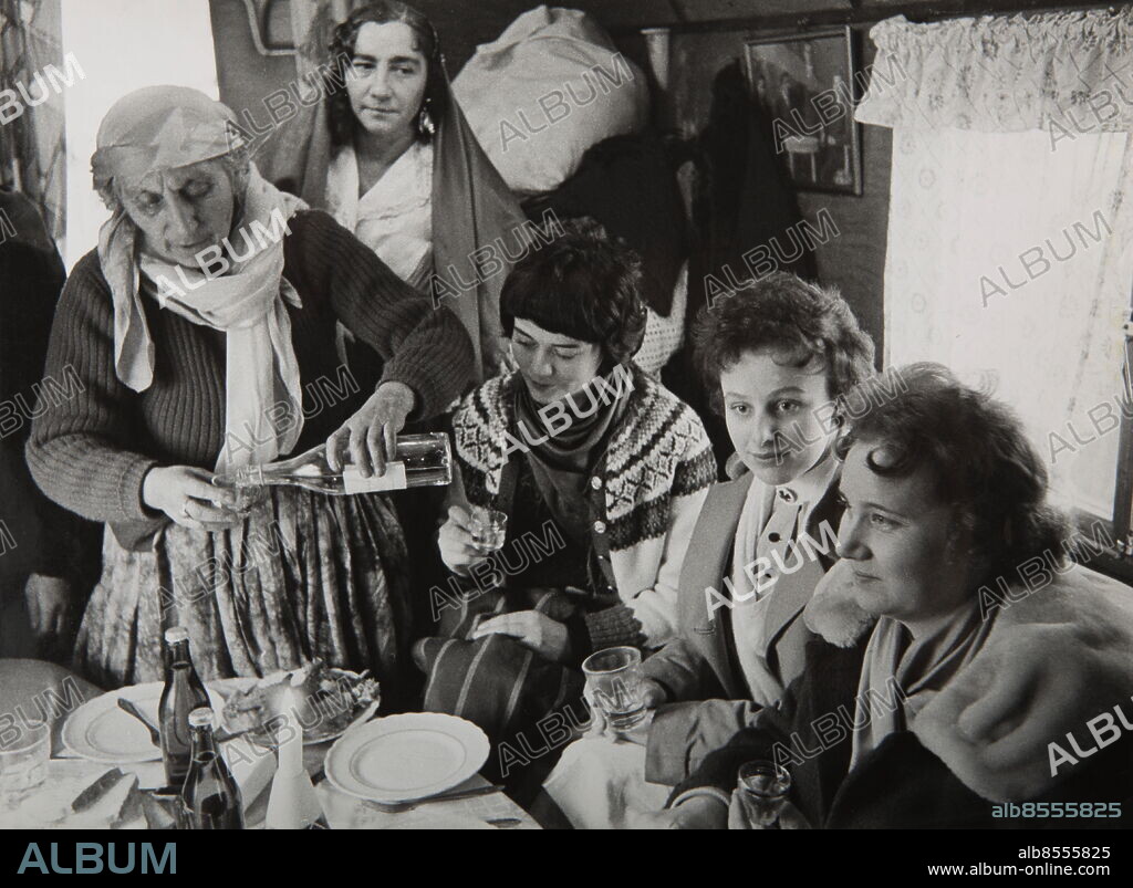 STOCKHOLM 1959-01-30. ORIGINALBILDTEXT: Bessik Taikons begravning.. Gästerna undfägnas vid ”osläktens” bord. Maria Taikon serverar tre av de biträden från Stureby vårdhem som varit med och skött hennes man, fr. v. Barbara Ericson, Berta Hagström och Gunnel Johansson.. Foto: John Kjellström / SvD / TT / kod 11014.