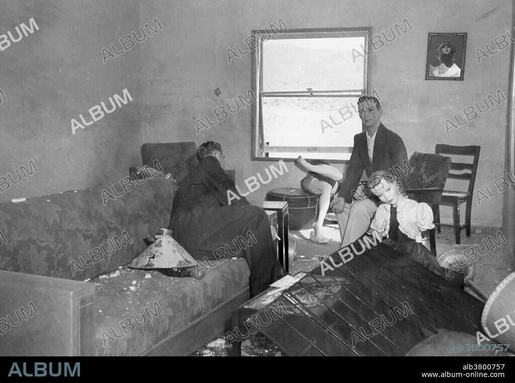 Four mannequins in damaged living room. Operation Doorstep was a civil defense study conducted by the Federal Civil Defense Administration in conjunction with Upshot-Knothole Annie. It studied the effect of the nuclear blast on two wooden frame houses, fifty automobiles and eight bomb shelters designed for residential use. The homes in the study were constructed in such a way as to minimize the thermal effects of Annie, with an eye towards determining if, in the absence of fire, the basement of the closer home (3,500 feet from the hypocenter) might shelter its occupants, while the second (at 7,500 feet) could remain standing. Both homes performed as expected under the conditions of their construction. Upshot-Knothole Annie was a nuclear weapons test conducted by the United States as part of Operation Upshot-Knothole. It took place at the Nevada Test Site on March 17, 1953, and was nationally televised. The live TV coverage was captured at the studio, presumably using at-the-time new magnetic tape sound technology, so it is a rare record of the sound an actual atomic bomb makes.