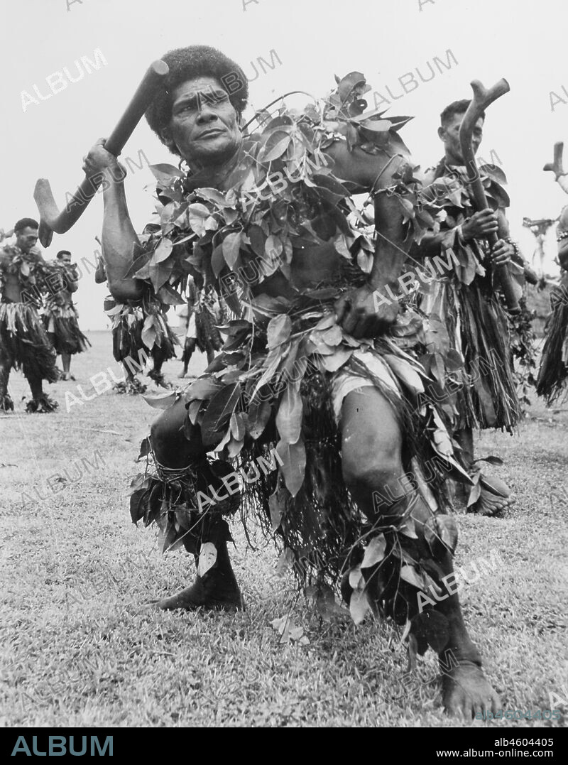 Fiji, Men perform the 'meke i wau'A group of men perform the 'meke i wau', a male dance from Fiji incorporating clubs. They dance wearing ceremonial costumes made from grass and leaves. Caption reads: A 'Meke' is a way the Fijians have of expressing themselves in a dance. The movements are always vigorous, for they portray phases of tribal battles, 1965. 2005/010/1/14/43.