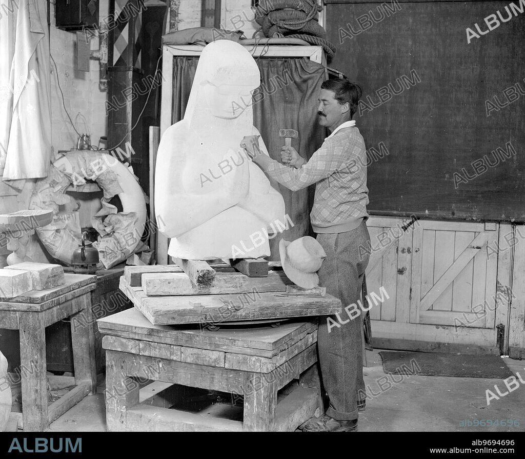 Mr Eric Kennington at his studio , Durham Wharf , Chiswick . He has been commissioned to do the Hardy Statue for Dorchester and is seen here putting the finishing touches to his work , 'A woman at Prayer '. 20 September 1929.