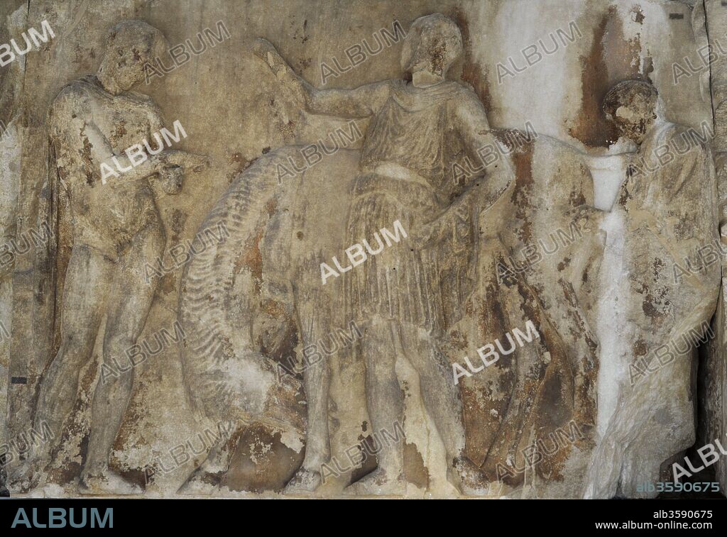 Arte Griego. Friso del Partenón de la Acrópolis de Atenas. Era Clásica. Siglo V a. C. Supervisado por Fidias. Hacia el 443-437 BC. Friso Oeste. Preparación de la procesión de las Panateneas. W XII, 22-24. En la figura central un heraldo (23) levantando su brazo para comenzar la procesión. A la izquierda un jinete (22) junto a su caballo. A la derecha un mozo (24), Museo de la Acrópolis. Atenas. Grecia.