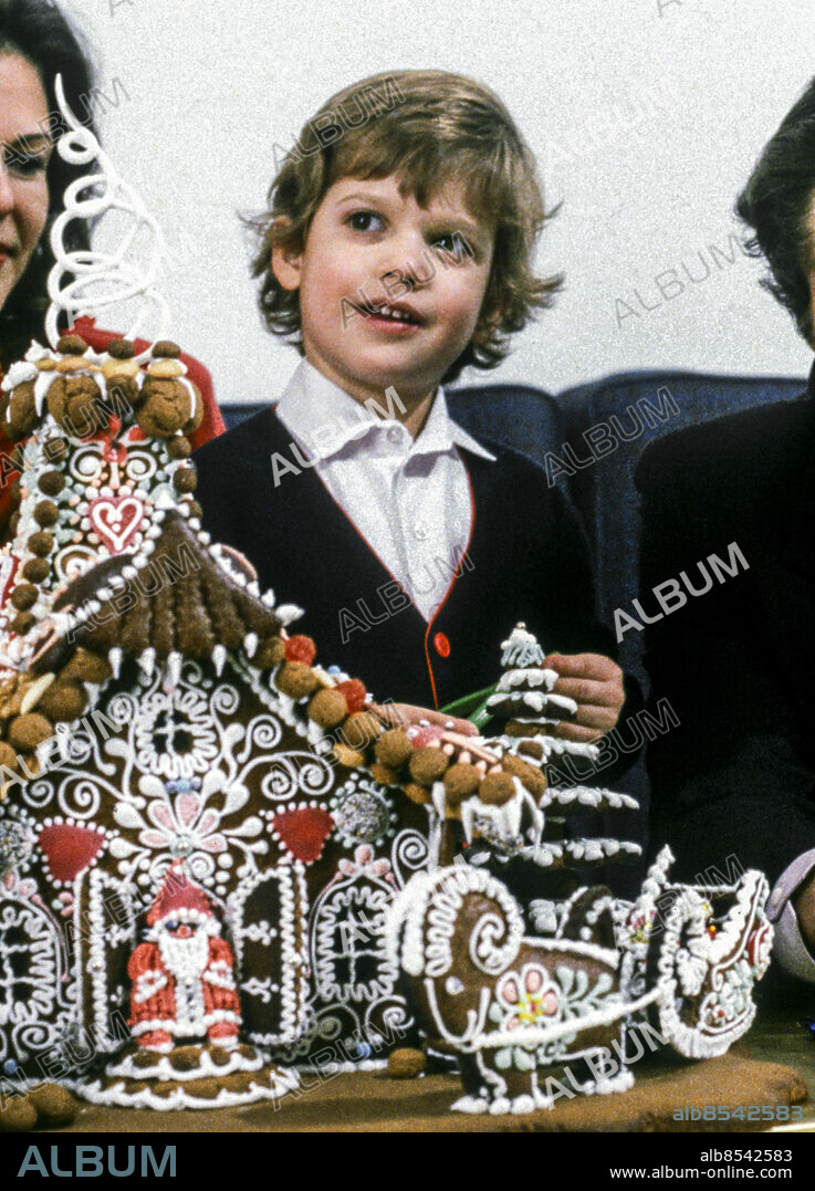 STOCKHOLM 1984-12-12. Prins Carl Philip sitter i soffan bakom ett pepparkakshus i samband med julfotograferingen av den svenska kungafamiljen på Drottningholms slott i december 1984.. Foto: Anders Holmström / TT / Kod: 50100.