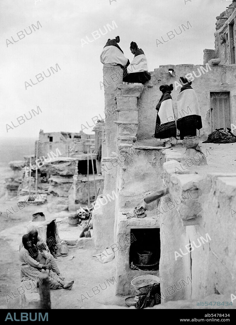 Edward S. Curtis Native American Indians - Photo shows Hopi women seated and standing on pueblo buildings circa 1906.