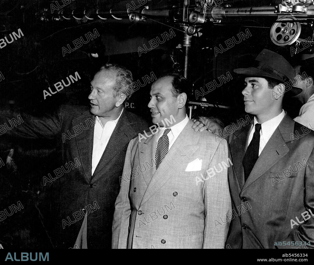 Mr. N.P. Pery, Managing Director of Columbia Pictures (Aust.) Pty. Ltd., being shown around the set of "Gallant Journey" whilst visiting his home office in Hollywood. Photographed with him is Glenn Ford, star of Columbia's "Gallant Journey. January 09, 1952. (Photo by Avery, Columbia Pictures).