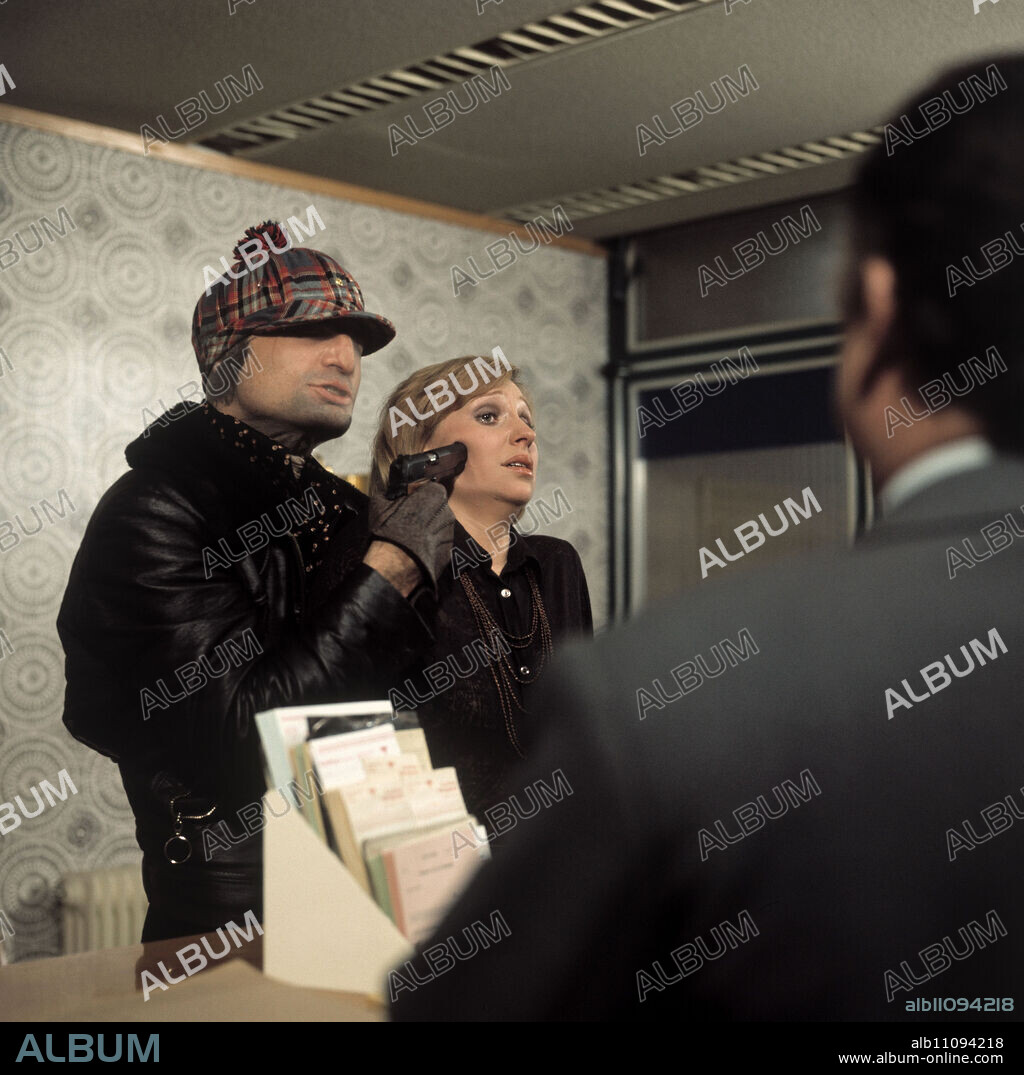 TATORT / Kurzschluss / BRD 1975 / Fritz Eckhardt, Wolfgang Peterse / Scene: Crook Piet Kallweit (DIETER LASER) threatens bank employee Inge Balke (SYLVIA DUDEK) with a weapon.