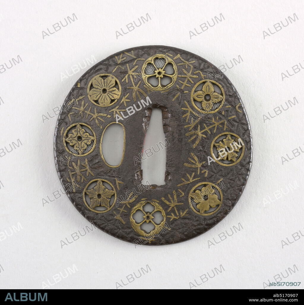 Tsuba, Pierced iron, engraved brass inlay, The iron tsuba is round in shape, with sukashi (openwork), and has hon zogan (true inlay) decoration of shinchu hira (flat brass) showing mon-jirushi ni mogosa (various crests with waterweed). This Bizen Yoshiro style of inlay does not stand above the surface of the iron, and was a specialty of the Fushimi Yoshiro, Takahashi school., At the center is the nakago-ana, an opening through which the sword passes. At left is sashi ura, the side which faces the blade. Its opening takes the hangetsu-kei (half moon) shape and has shinchu fukurin (brass rim) covers. Surrounding these openings, is the seppadai, a flat oval area that is migaki (burnished). The rim of the tsuba is round, or maru-mimi., Japan, 15961615, metalwork, Decorative Arts, Tsuba.