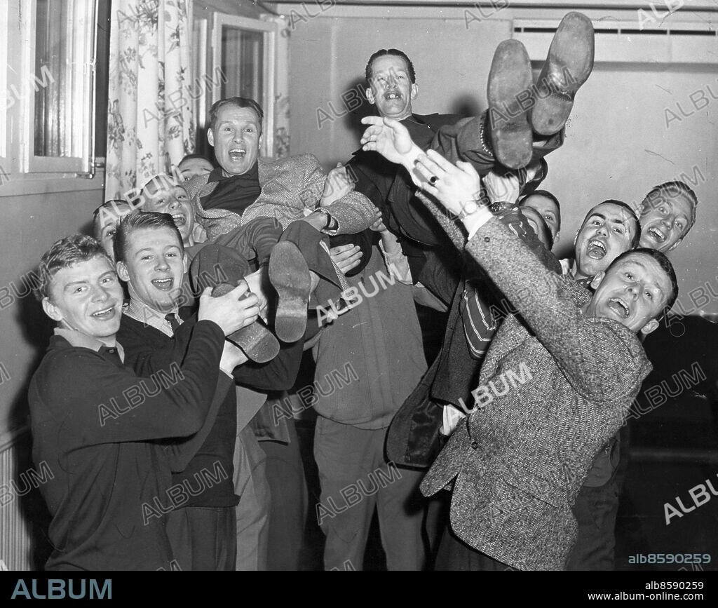 Stockholm 1960-03-02. AIK till allsvenskan i ishockey. Ära den som äras bör. Tränaren Svante Granlund till vänster och lagledare Lucke Lööv åker i luften. I klubbrummet.. Foto: Arrne Schweitz / Expressen / TT / Kod: 192. ** AFTONBLADET OUT **.
