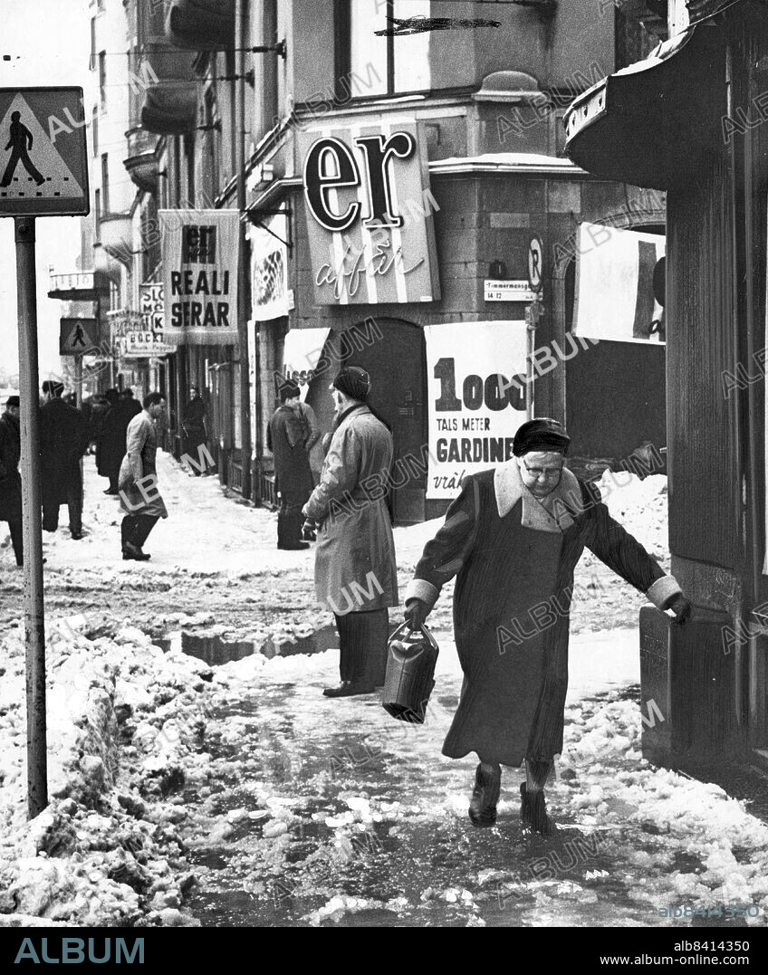 Stockholm 1959-01-21. Vinter i Stockholm. Det var nästan vårstämning på Hornsgatan på onsdagseftermiddagen där NoN-fotografen tog denna bild av snösmältning, realisationer och handlande Söderbor.. Foto: Carl-Erik Sundström / DN / TT / Kod: 59. ** SvD OUT **.
