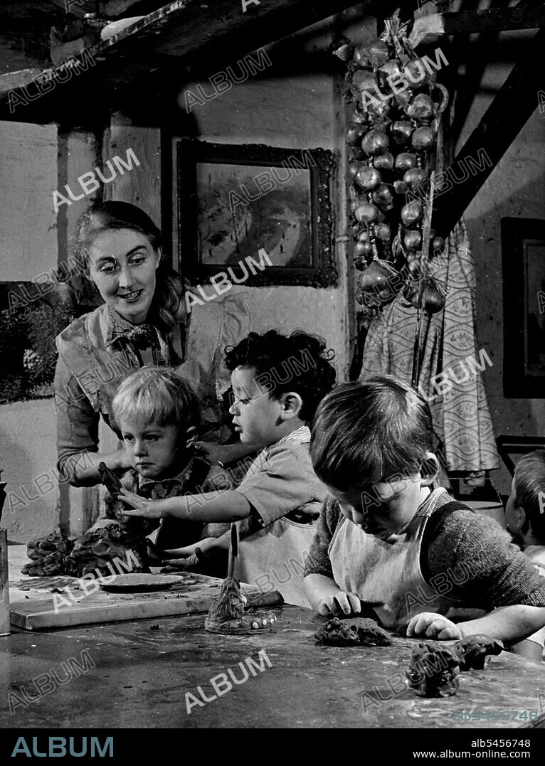"Course it's an elephant," says Caron Rawnsley (left) as Bareno Velleman dubiously fingers the lump of clay Caron has been modelling. Jonathan Levy is busy with what he says is a railway train. Caron and his friends, watched over by Mrs. Rawnsley, are playing in artist David Rawnsley's Chelsea (London) studios where, since David Started making pottery, there is plenty of modelling clay for little fingers to muck about with. September 15, 1952.