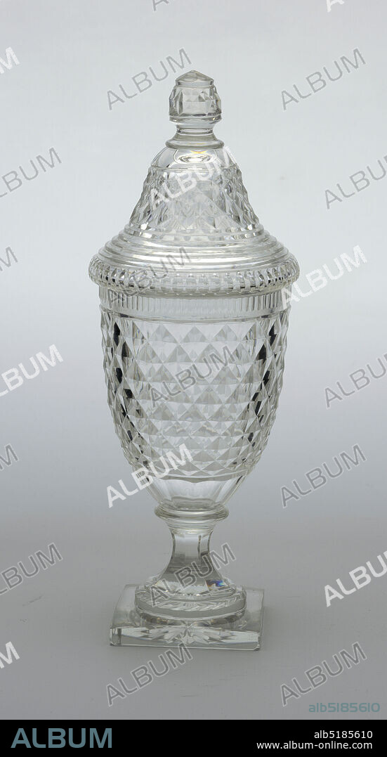 Jar and lid, Glass, Slender urn-shaped body, cut with shallow diamond pattern all over, a row of thin fluting top edge, wider fluting at base; fluted stem on square base cut with star on bottom; tall bell-shaped cover cut with shallow diamonds and prismatic rings, faceted finial., England, ca. 1830, glasswares, Decorative Arts, Jar and lid.