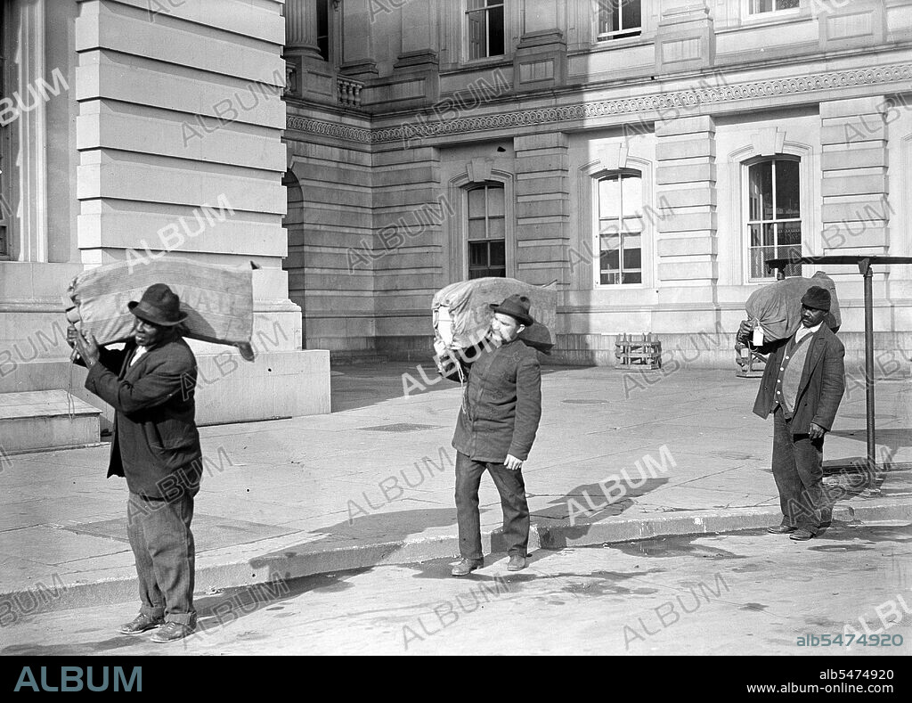 Workers carrying bags of franked mail at the U.S. Capitol circa 1913.