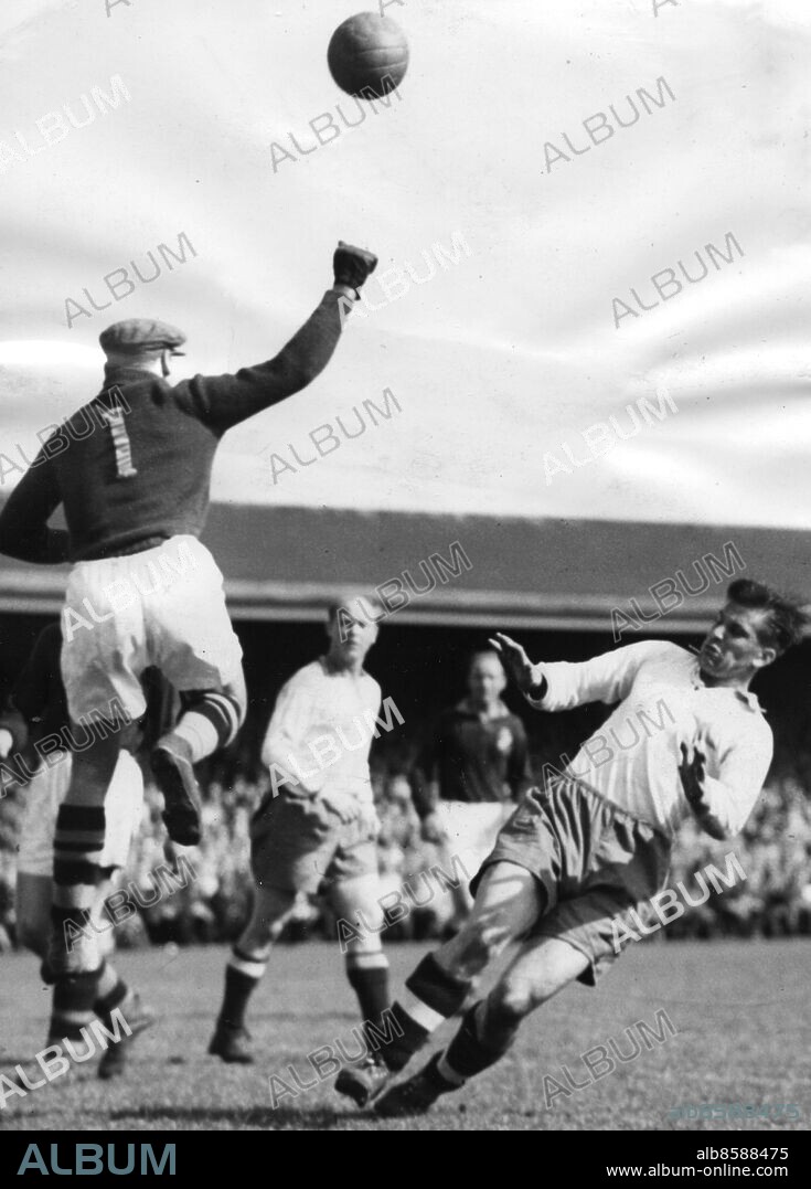NORRKÖPING 194805. Gustav "Gurra" Sjöberg boxar bort bollen från Gunnar Nordahl i Idrottsparken i Norrköping. I bakgrunden Norrköpings Erik "Mulle" Holmqvist och AIK:s Harry Johansson. Matchen slutade 3-1 till hemmalaget. När allsvenskan spelats färdigt stod Norrköping som allsvenska mästare för fjärde året i följd. Foto: Text & Bilder / SVT / Kod: 5600.