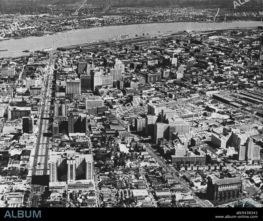 American Views: New Orleans, Louisiana Aerial view showing the city's growing skyline, with the Mississippi River in the background. At left is Canal Street, the city's principal shopping district; centre right is the State Charity Hospital and Tulane and Louisiana State University Medical Centres. New Orleans has a population of 570, 455. December 16, 1954. (Photo by Camera Press).;American Views: New Orleans, Louisiana Aerial view showing the city's growing skyline, with the Mississippi River.