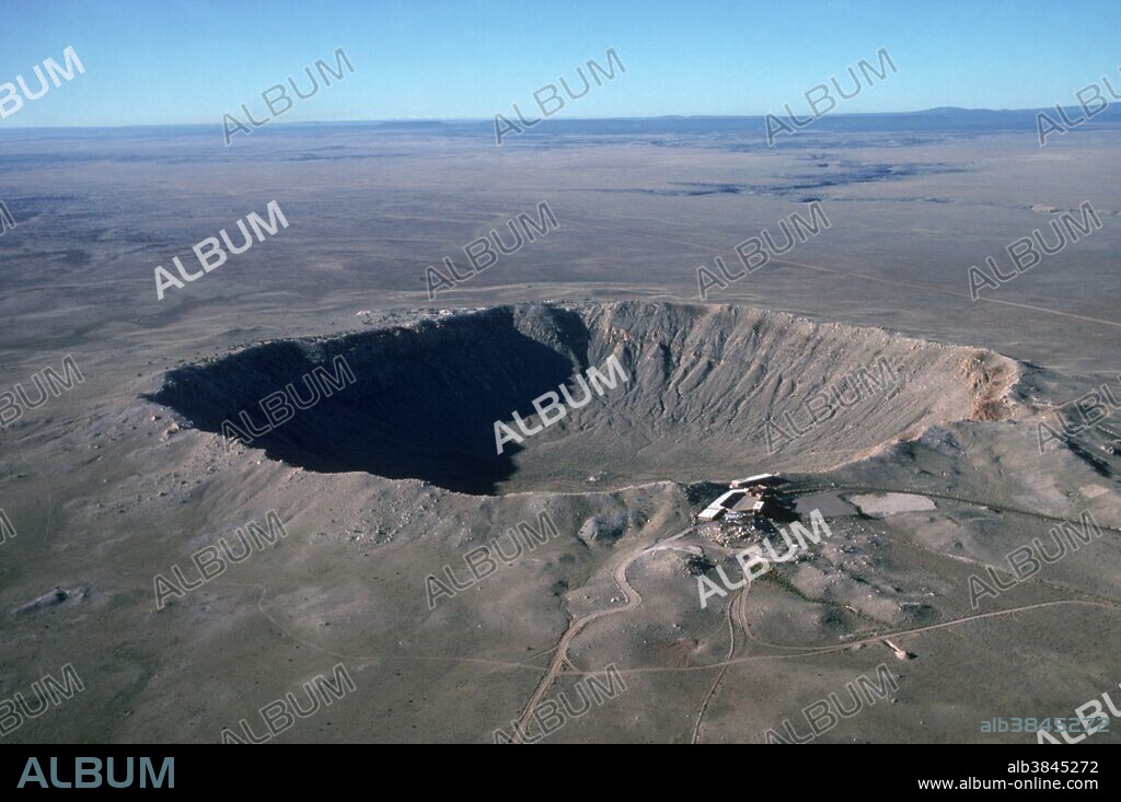 Aerial view of Meteor Crater, Arizona. It is also called the Barringer Crater, after the mining engineer who first suggested that it was formed by a meteor impact. It is about 50, 000 years old and is about 200 meters deep and 800 meters across. Several attempts to mine the iron- rich material of the meteor were made before a visitor center was built in the 1960's. Two new minerals - coesite and stishovite - were identified here; both are forms of silica created at high temperatures and pressures. In recent years the crater has been used for astronaut training & studies in planet comparison.