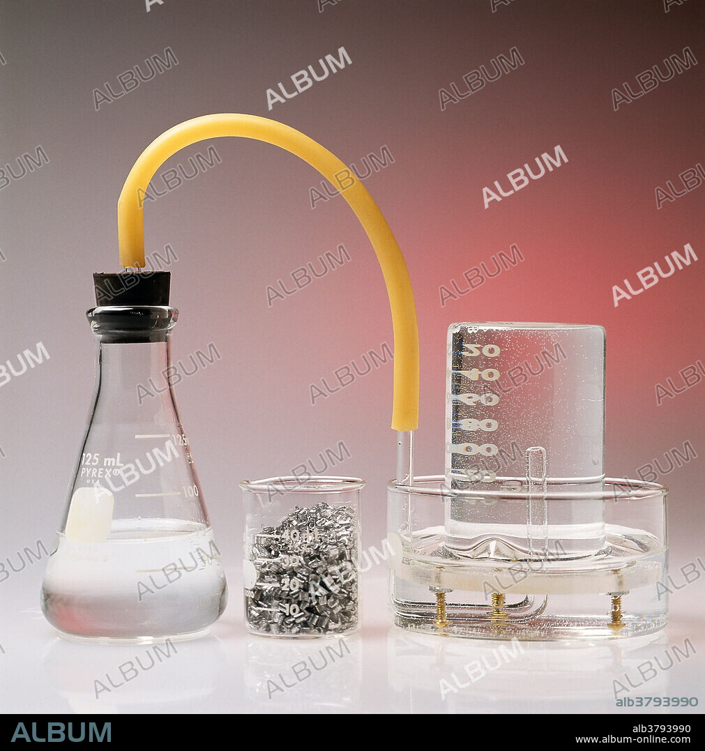 Placing magnesium in hydrochloric acid (HCl) generates hydrogen gas (in the flask on the left), which bubles into the upside down beaker (on the right), forcing the water level to go down.