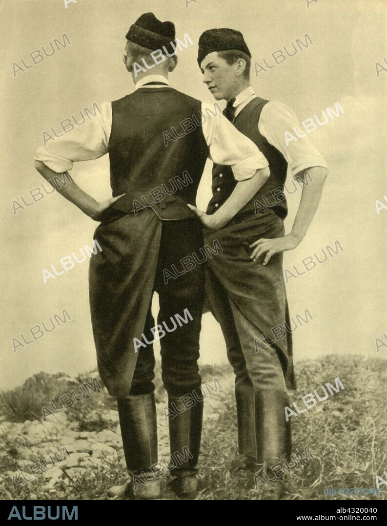 Young men in traditional costume, Burgenland, Austria, c1935. Men from the state of Burgenland in caps and waistcosts, wearing the Firta over knee-high boots. The Firta is a kind of apron or cloth worn around the waist by the men, one corner of which is tucked into the waistband at the hip, on the right-hand side for single men and the left for married men. From "Österreich - Land Und Volk", (Austria, Land and People). [R. Lechner (Wilhelm Müller), Vienna, c1935].