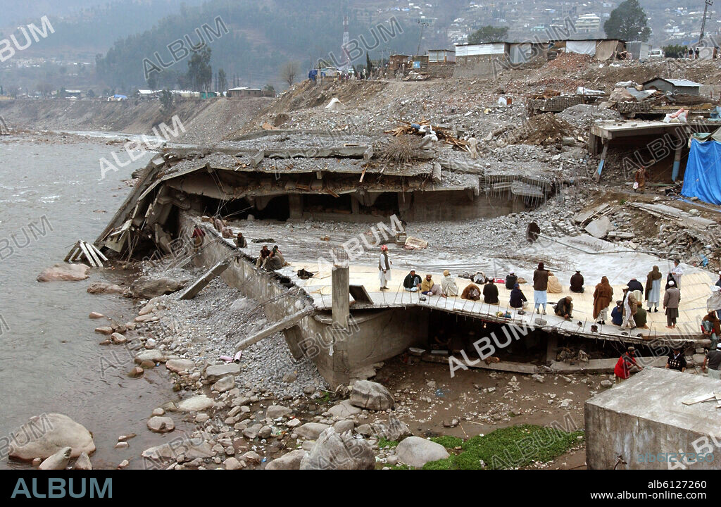 People sit in the ruins of the town of Balakot, Pakistan, 31 January 2006. The town had almost completely been destroyed by an earthquake, killing an estimated 20.000 people. The north-eastern province of Cashmere, Pakistan had been hit by an earthquake of the strength of 7,6 on 8 October 2005. Nearly 80.000 people had been killed, more than three millions were made homeless and suffered severely due to the cold winter. Photo: Wolfgang Langenstrassen. 31/01/2006