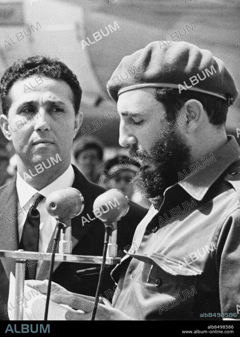 Orig. bildtext... BEN BELLA IN HAVANA The Premier of the Algerian People's Democratic Republic, Ahmed Ben Bella, is making an official visit to Cuba. He was given an enthusiastic welcome upon his arrival today at noon, in the International Airport José Marti. The Algerian leader was received by Dr. Osvaldo Dorticos Torrado, the Cuban President, and Premier Major Fidel Castro. 3. Premier Major Fidel Castro, resding a reception message to the Algerian Premier, who is standing at his side. Anm. Se även BBA268 och BBF931-BBF939 Bildserier Fotoreportage Profiler Basker Talare persons: AHMED BEN BELLA;FIDEL CASTRO sites: ALGERIET*;NORDAFRIKA*;AFRIKA*;CUBA;HAVANNA.