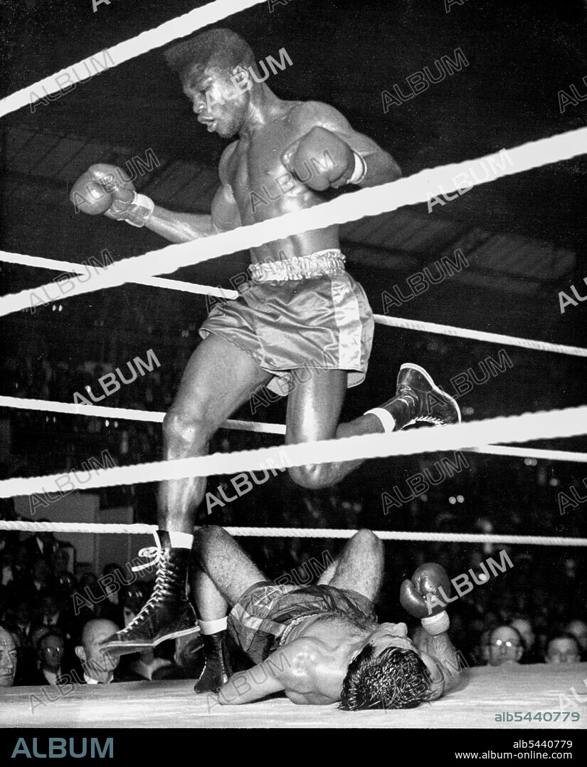 Phillips Retains His Title - Loser's leap. Cliff Anderson jumps over Phillips, flat on the canvas after a succession of blows to the body, as the bell goes to end the sixth round of the fight to night. Al Phillips of Aldgate retained his featherweight championship of the British Empire against Cliff Anderson of British Guiana at Olympia to-night (Tuesday). Phillips was awarded the contest on a foul in the eighth of fifteen rounds. July 1, 1947.
