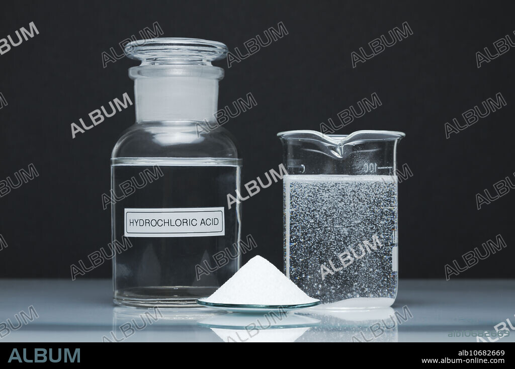 Baking soda reacts with acid. A 0.1M solution of hydrochloric acid (HCl, left, reagent bottle) reacts in a beaker (right) with solid baking soda (NaHCO3, centre, watchglass). Carbon dioxide bubbles are produced: NaHCO3 + HCl -> NaCl + H2O + CO2.