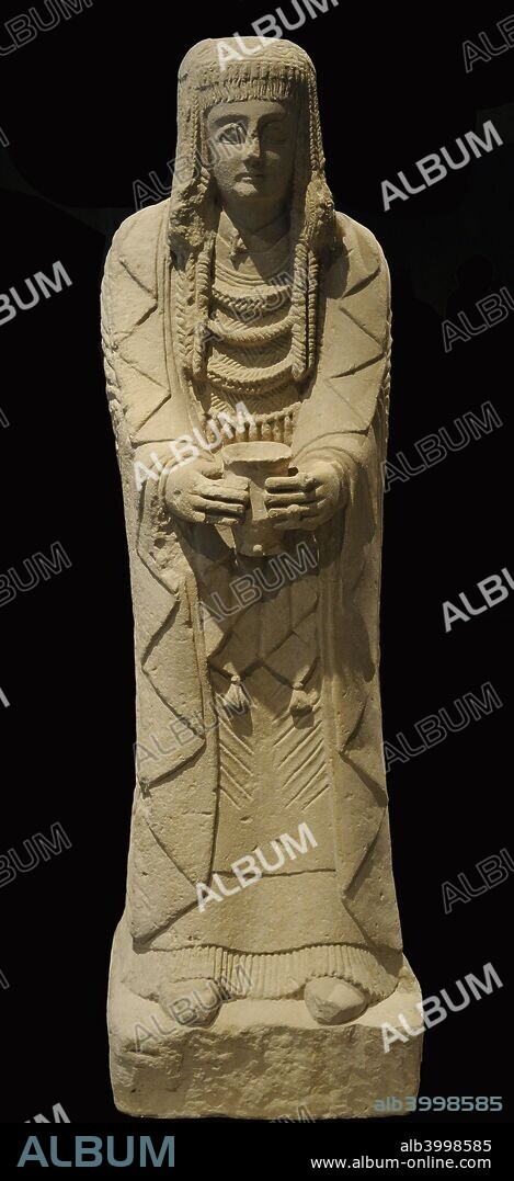 Gran Dama Oferente. Cultura Ibérica. Siglo III a. C. Escultura femenina en actitud oferente. Ataviada con tres túnicas superpuestas, la superior atada al cuello con una fíbula tipo La Tène. Sus joyas indican su elevado estatus social. Peinada con tirabuzones y un postizo rematado con rodetes. Identificado como parte de un rito de paso de edad. Piedra caliza. Procedente del Santuario del Cerro de los Santos (Montealegre del Castillo, provincia de Albacete). Museo Arqueológico Nacional. Madrid. España.