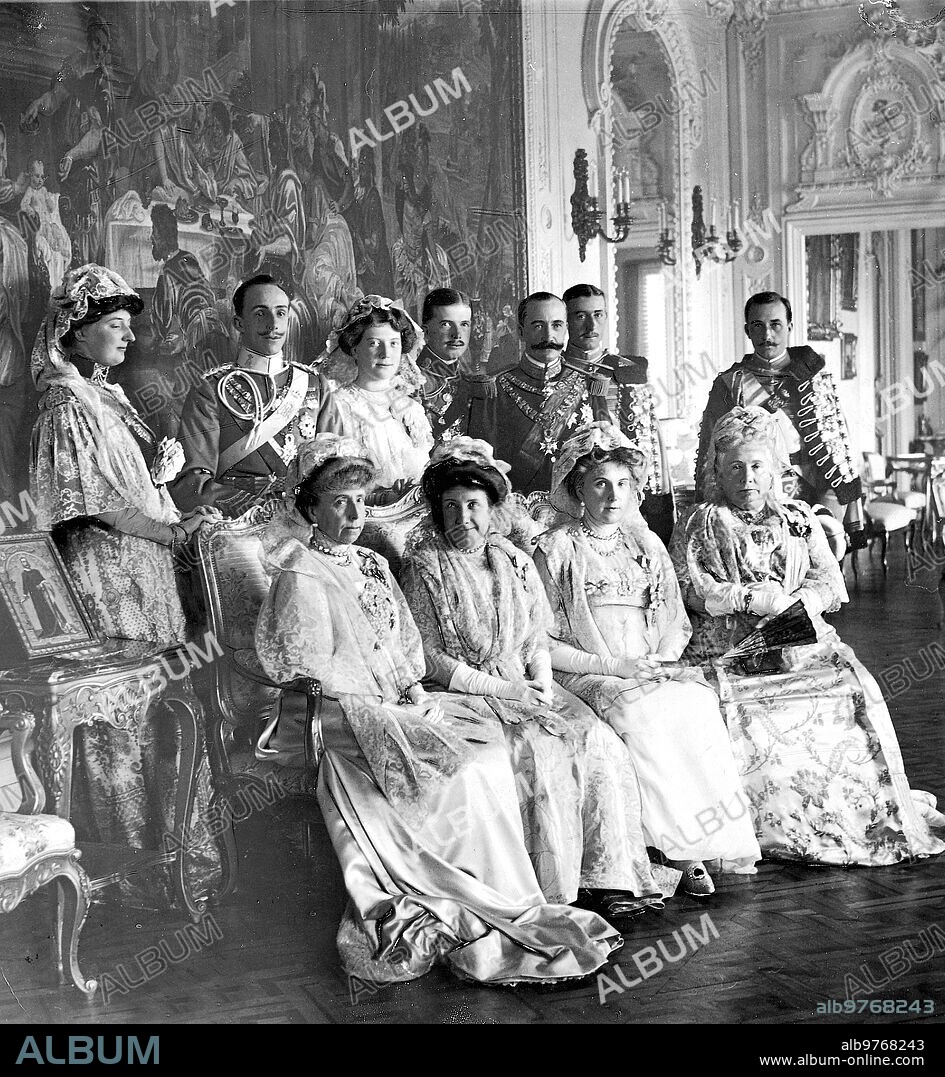 Octubre 1911. Después del bautizo de María de las Mercedes. - la familia real en el salón del palacio de los Infantes D. Fernando y de Dña. María Teresa, de izquierda A derecha Sentados: la Reina Dña. María Cristina, la Infanta Dña. Paz, la Reina Dña. Victoria Eugenia, la Infanta Dña. Isabel: de Pie, la Infanta Dña. Luisa, S. M el Rey , la Infanta Dña. Pilar , los Infantes D. Fernando , D. Carlos y D. Felipe y D. Rainiero.